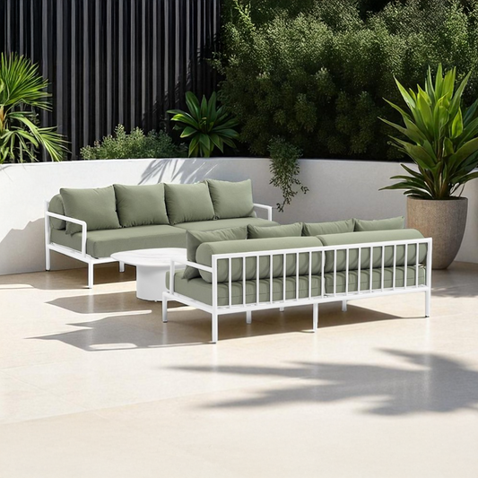 White outdoor sofa and daybed with green fabric cushions.